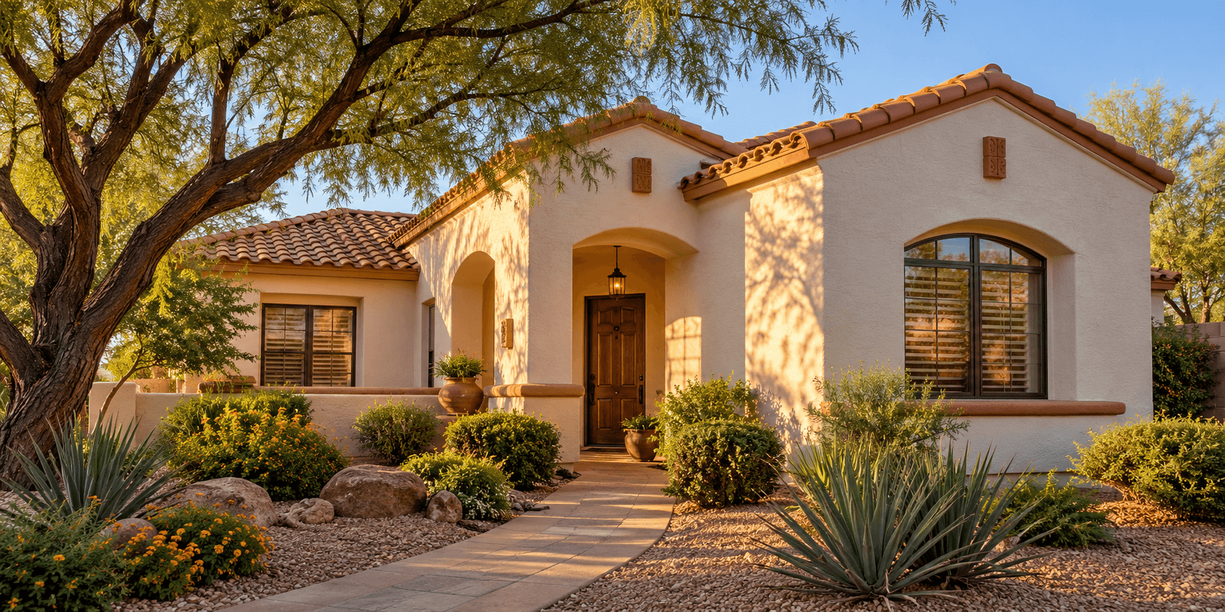 Sunlit stucco home with desert landscaping